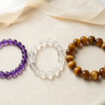 Three crystal bead bracelets of different bead sizes on cream linen with a measuring ribbon