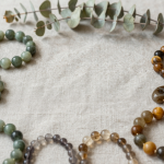 Earth element crystal bracelets in green jade, tiger's eye and moss agate on linen