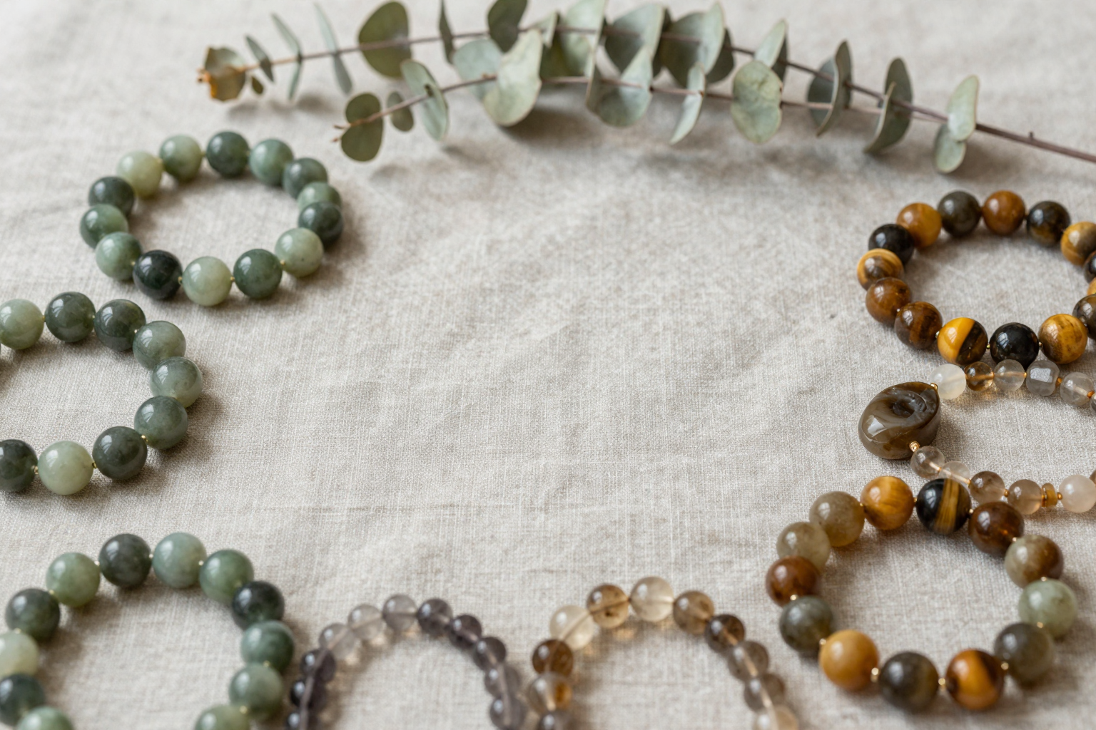 Earth element crystal bracelets in green jade, tiger's eye and moss agate on linen