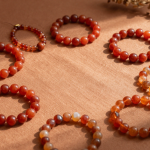 Fire element crystal bracelets in red agate, carnelian and citrine arranged on terracotta linen