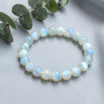 Rainbow moonstone bead bracelet with blue adularescence glow on gray silk