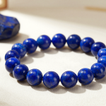 Lapis lazuli bead bracelet with golden pyrite flecks, flat-lay on ivory linen