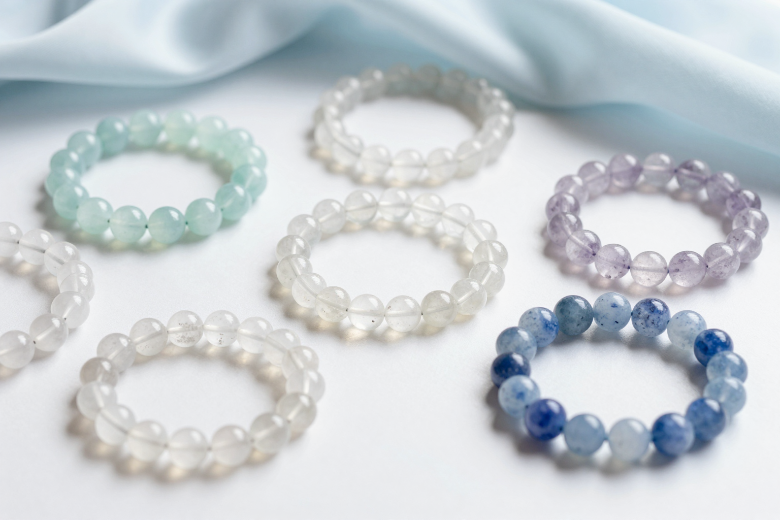 Air element crystal bracelets in aquamarine, clear quartz and blue lace agate on pale silk